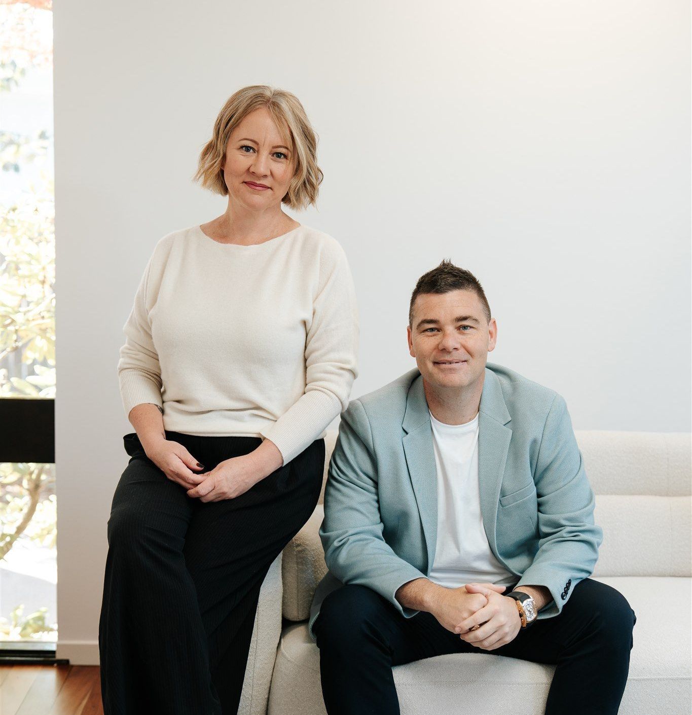 A Man and a Woman Sitting next to each other on a couch — Hyde Burchell Buyers Agents In Canberra, ACT