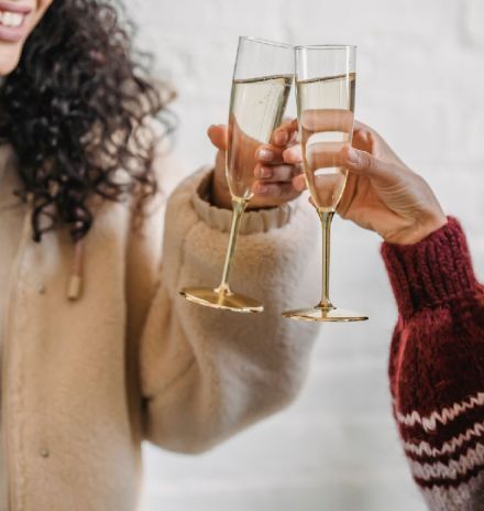 A Woman and a Man Are Toasting With Champagne Glasses — Hyde Burchell Buyers Agents In Canberra, ACT