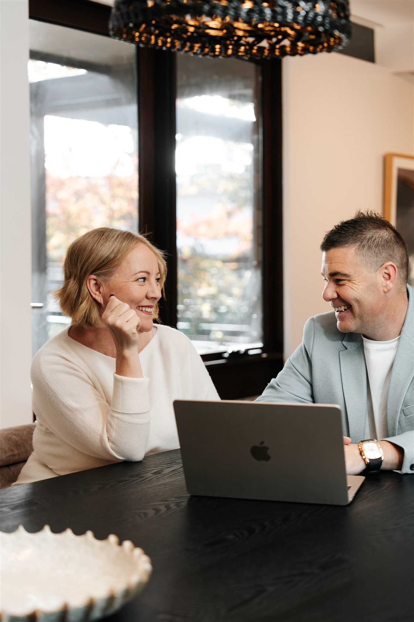 A Man and a Woman Are Sitting on the Floor in Front of a Window — Hyde Burchell Buyers Agents In Canberra, ACT