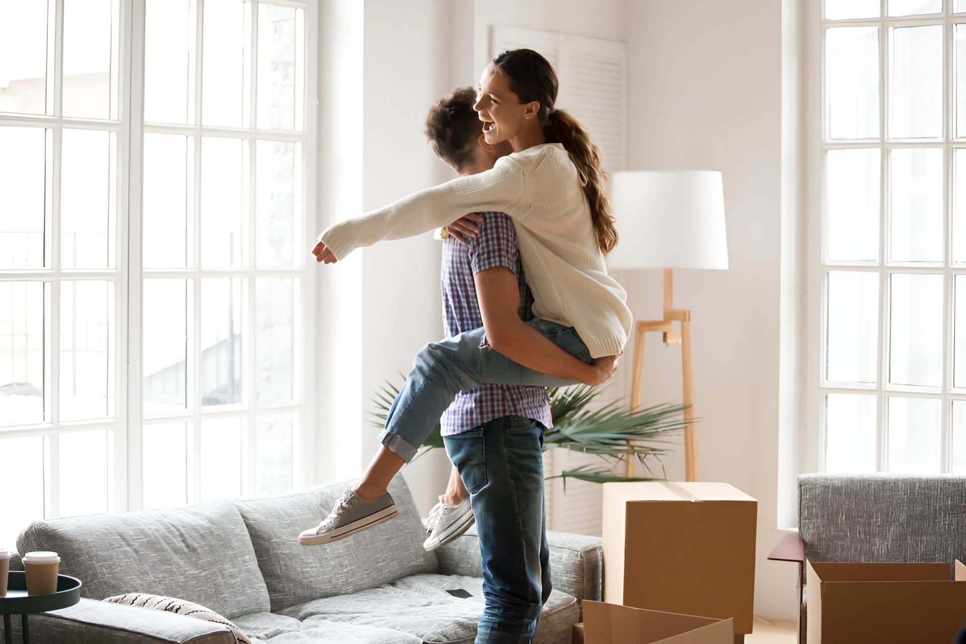 A Man is Carrying a Woman in a Living Room — Hyde Burchell Buyers Agents In Canberra, ACT