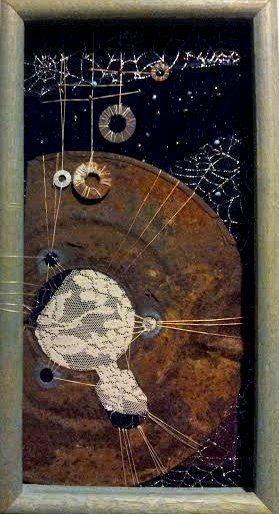 A piece of art framed and made of fabric and rusted found material resembling a nebula.