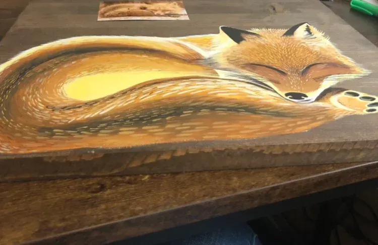 Painting of a baby red fox curled up sleeping on a wooden canvass.