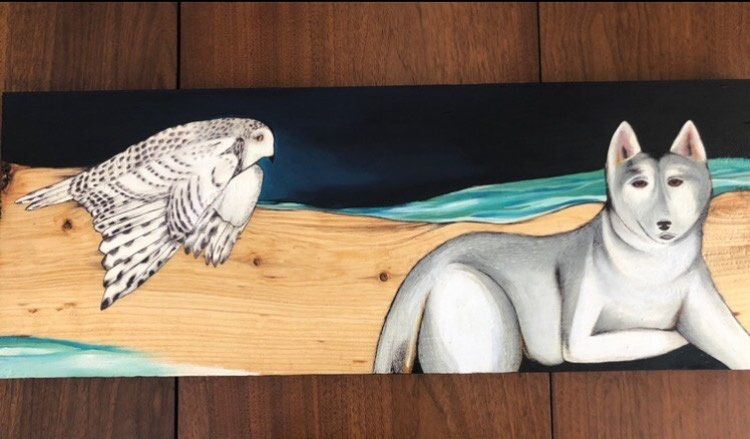 Painting of a husky dog and a snow owl flying above with sand and lake in the background.
