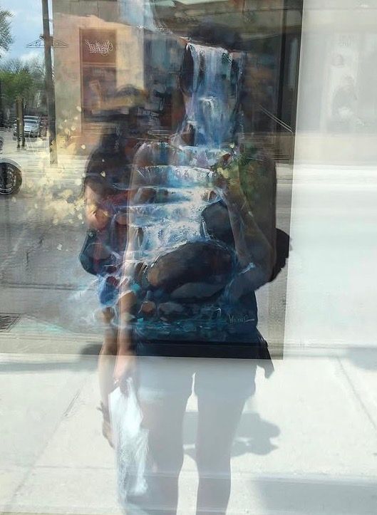 Image of a woman looking at her reflection of her body distorted as a waterfall. 
