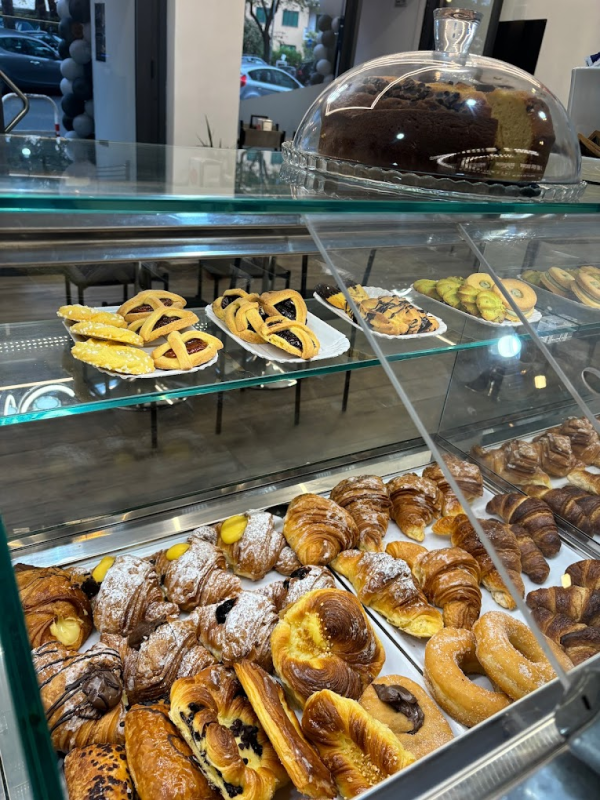 Una vetrina piena di una varietà di pasticcini e una torta.