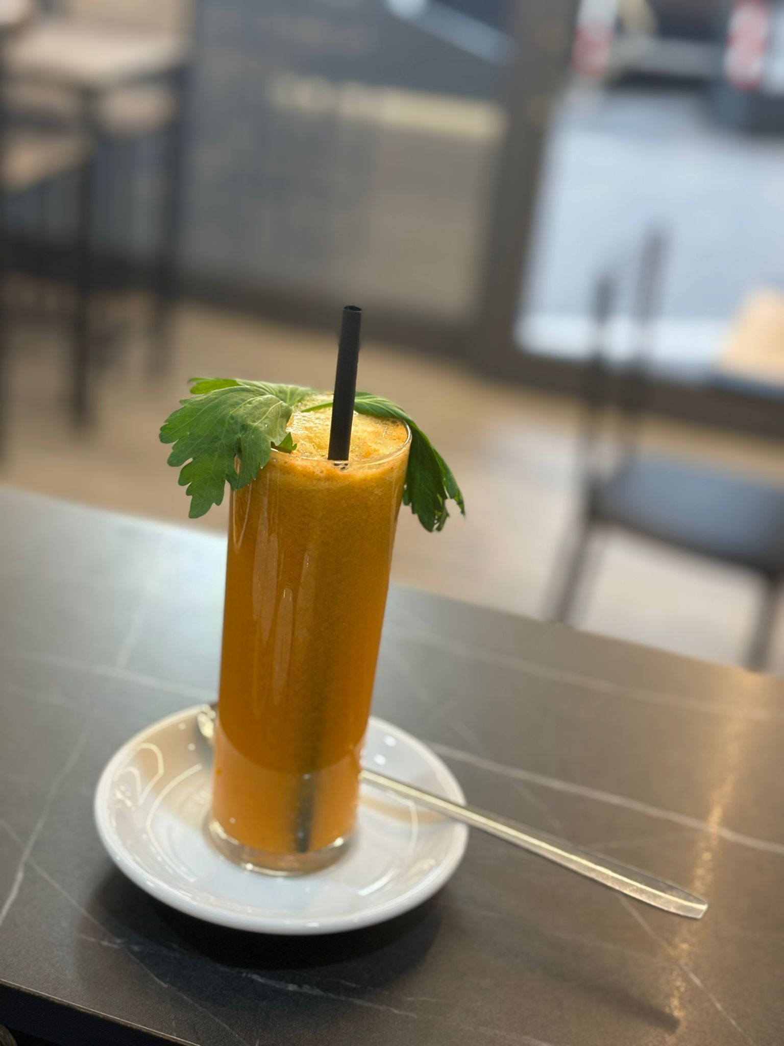 Un bicchiere di succo d'arancia con sopra una cannuccia