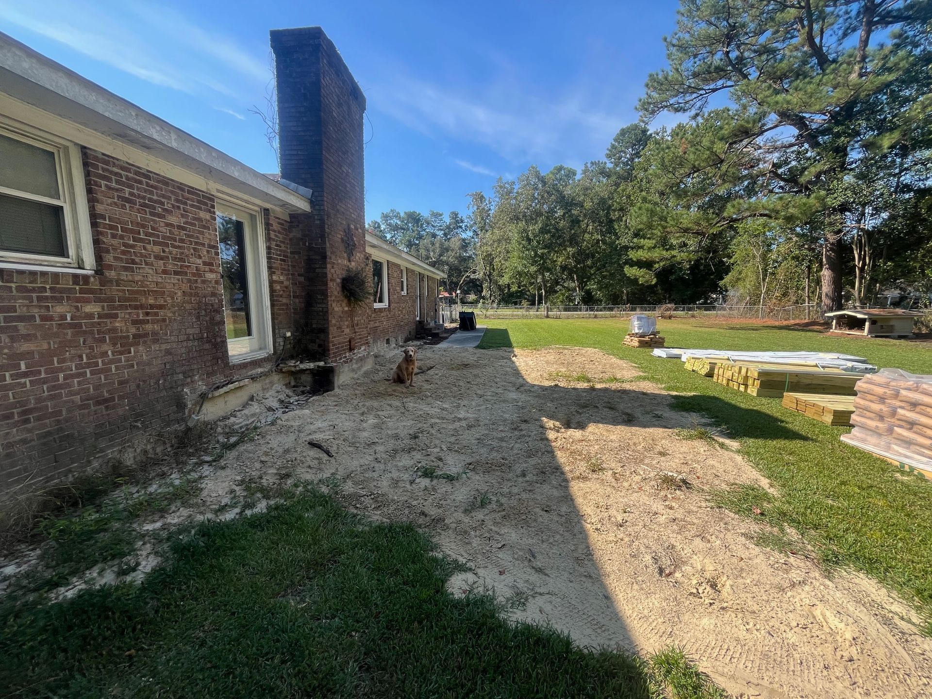 Screened porch addition with white trim, attached to brick home, set in grassy yard.