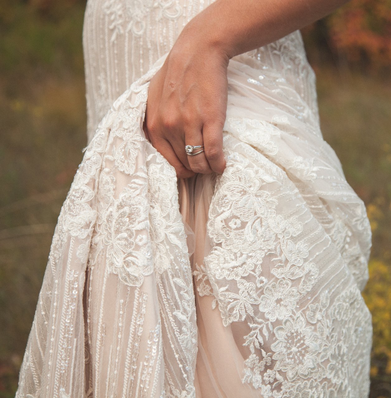 A woman wearing a wedding dress with a ring on her finger
