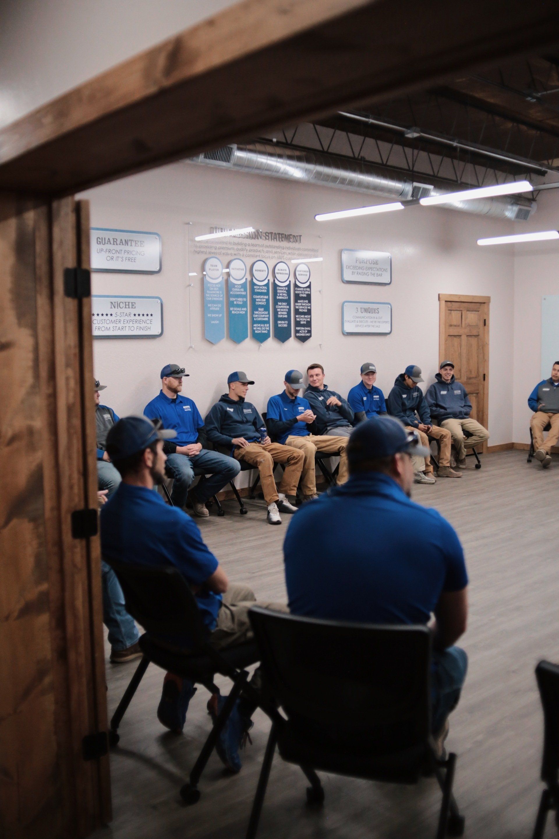 A group of men are sitting in a circle in a room.