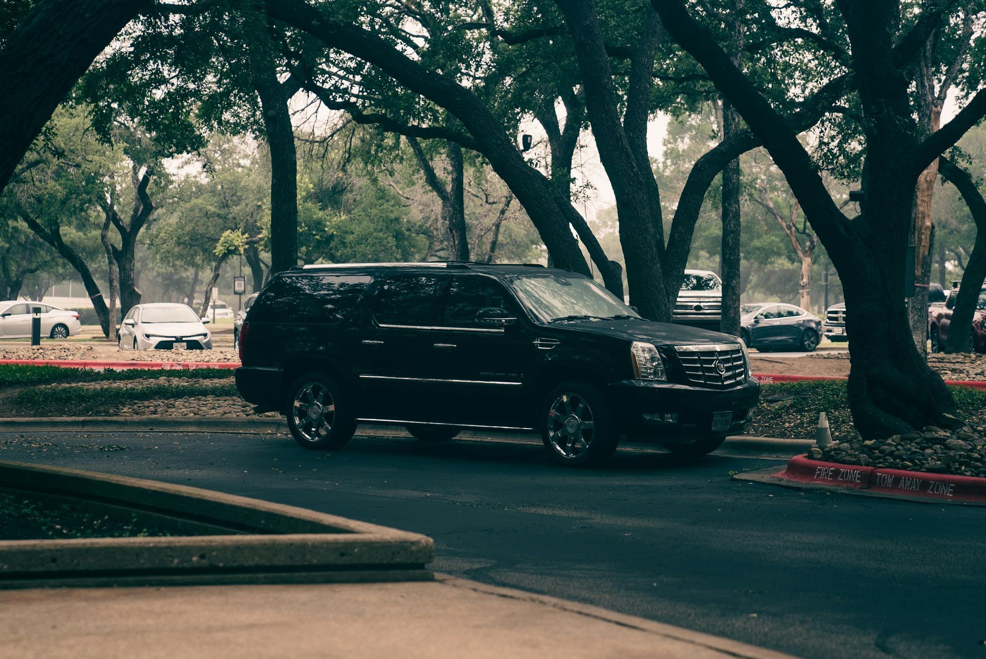 A black range rover is parked in a parking lot with its doors open.