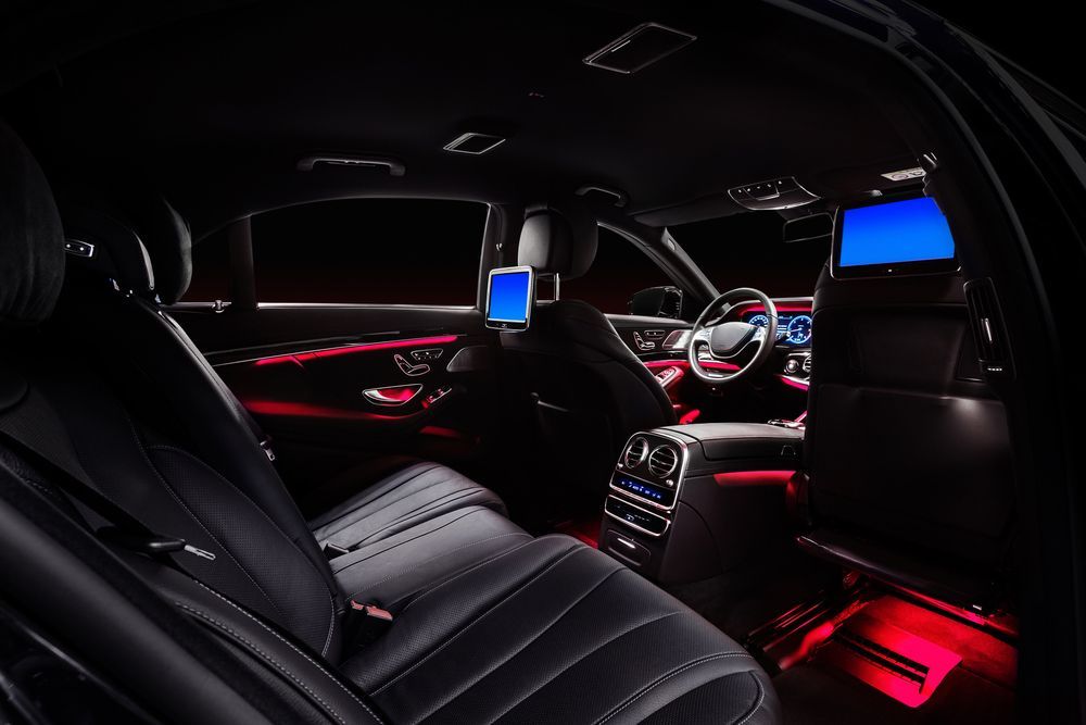 The interior of a car with red and blue lights on the seats.