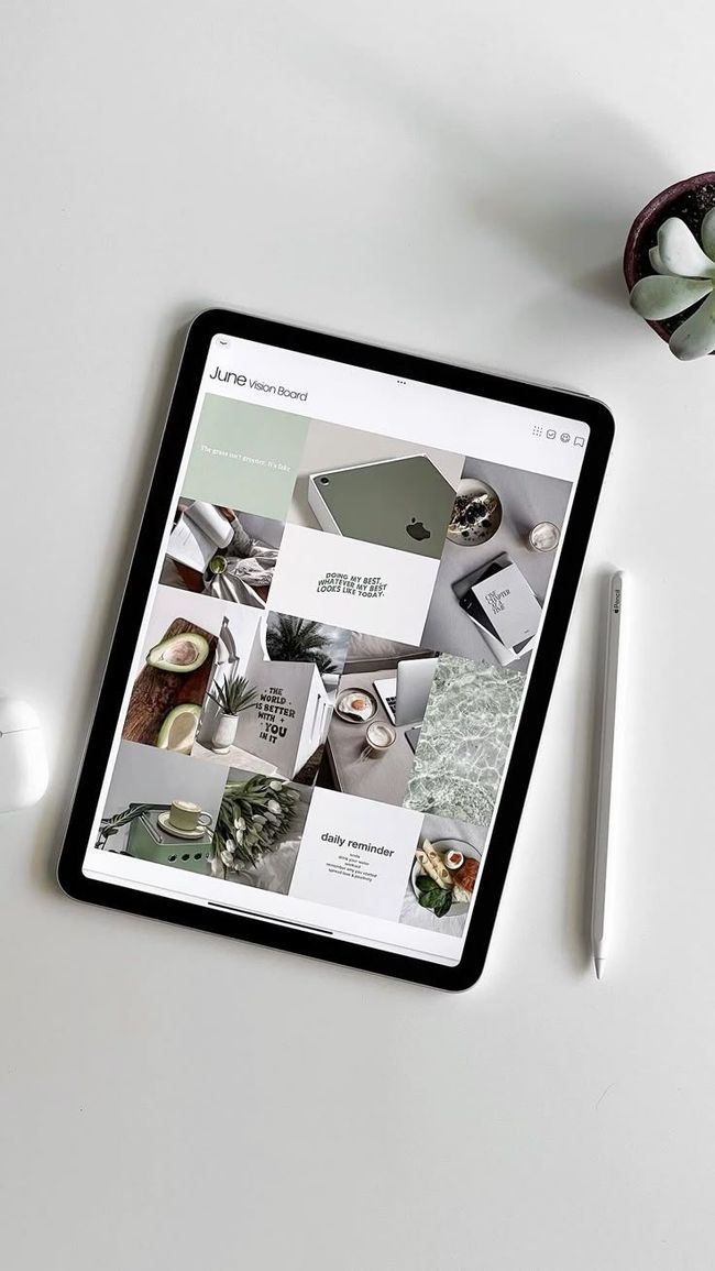 A tablet is sitting on top of a white table next to a pen.