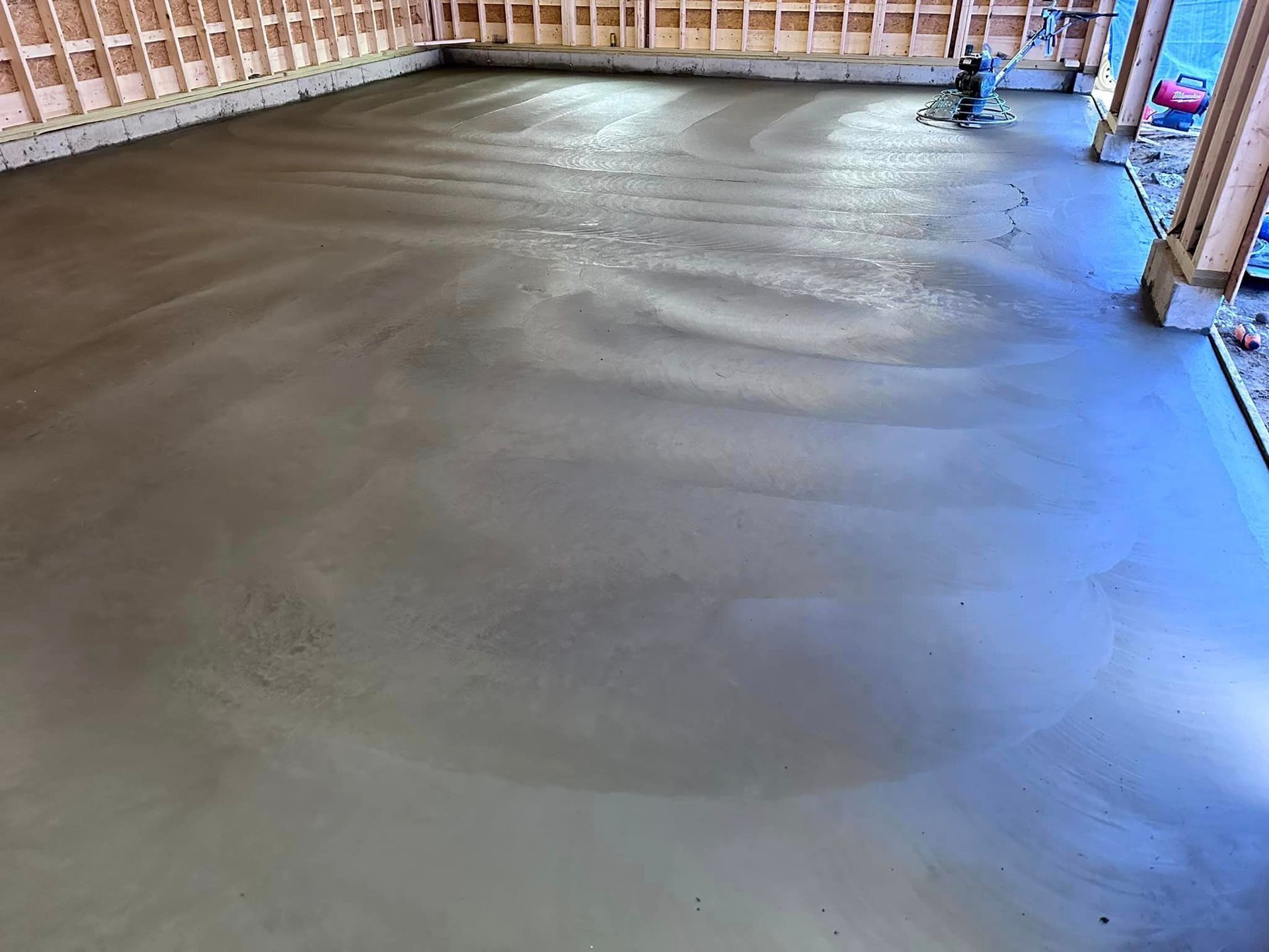 A concrete floor is being poured in a building under construction.