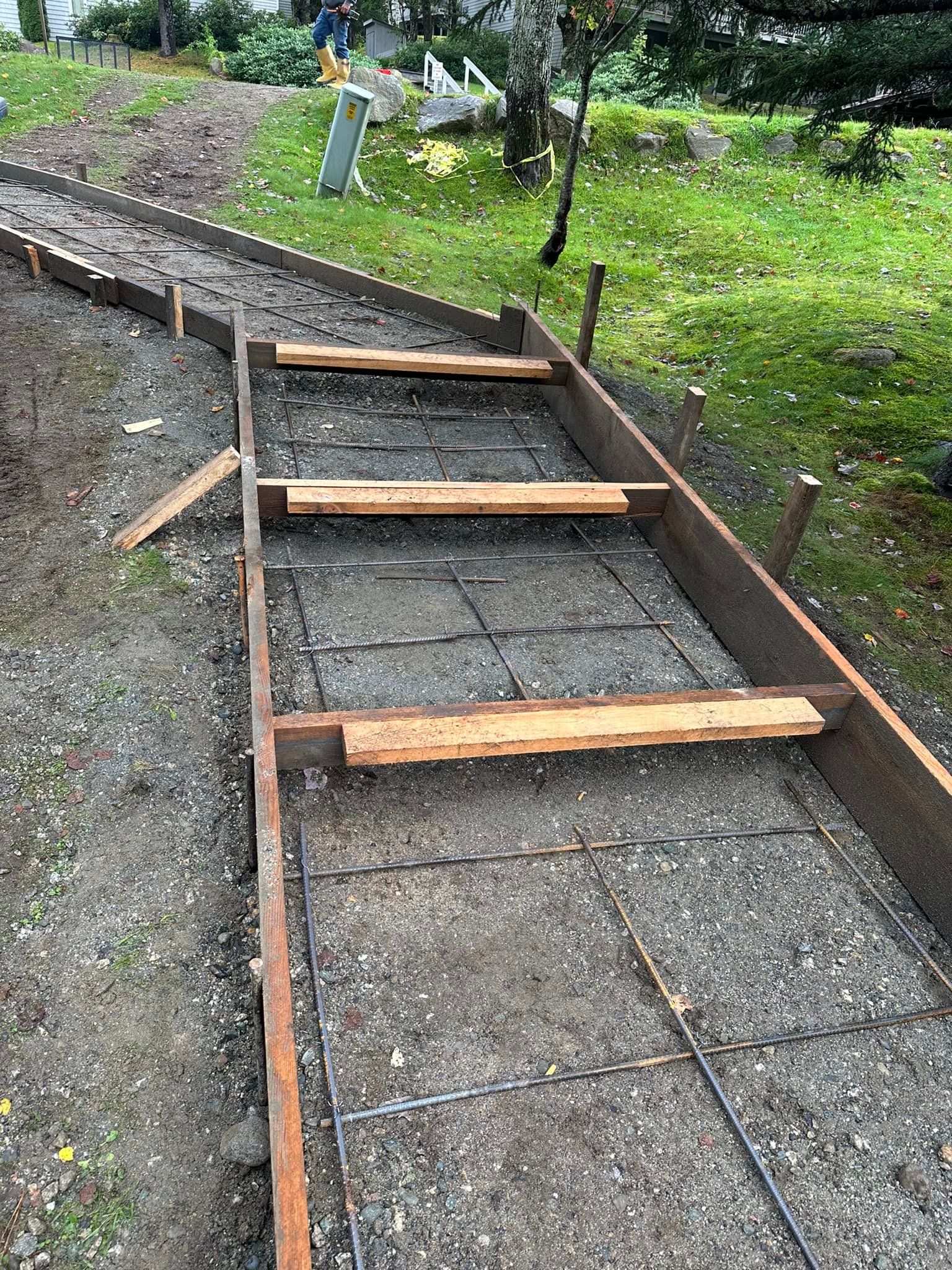 A concrete walkway is being built with wooden steps.