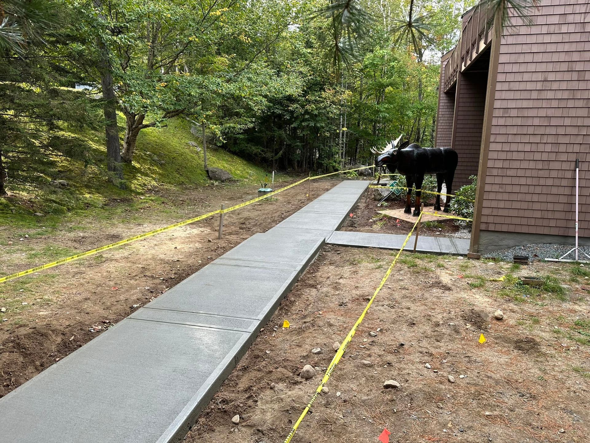 A concrete walkway is being built in front of a brick building.