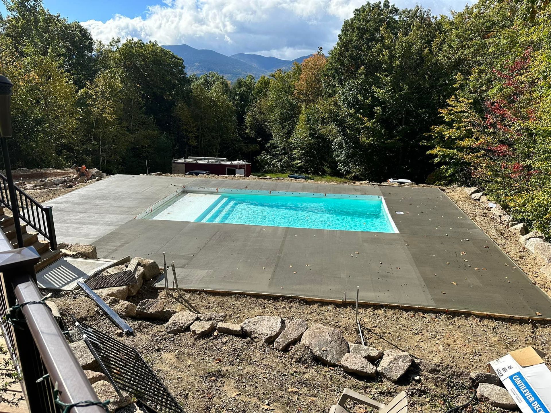 A swimming pool is being built in the backyard of a house.
