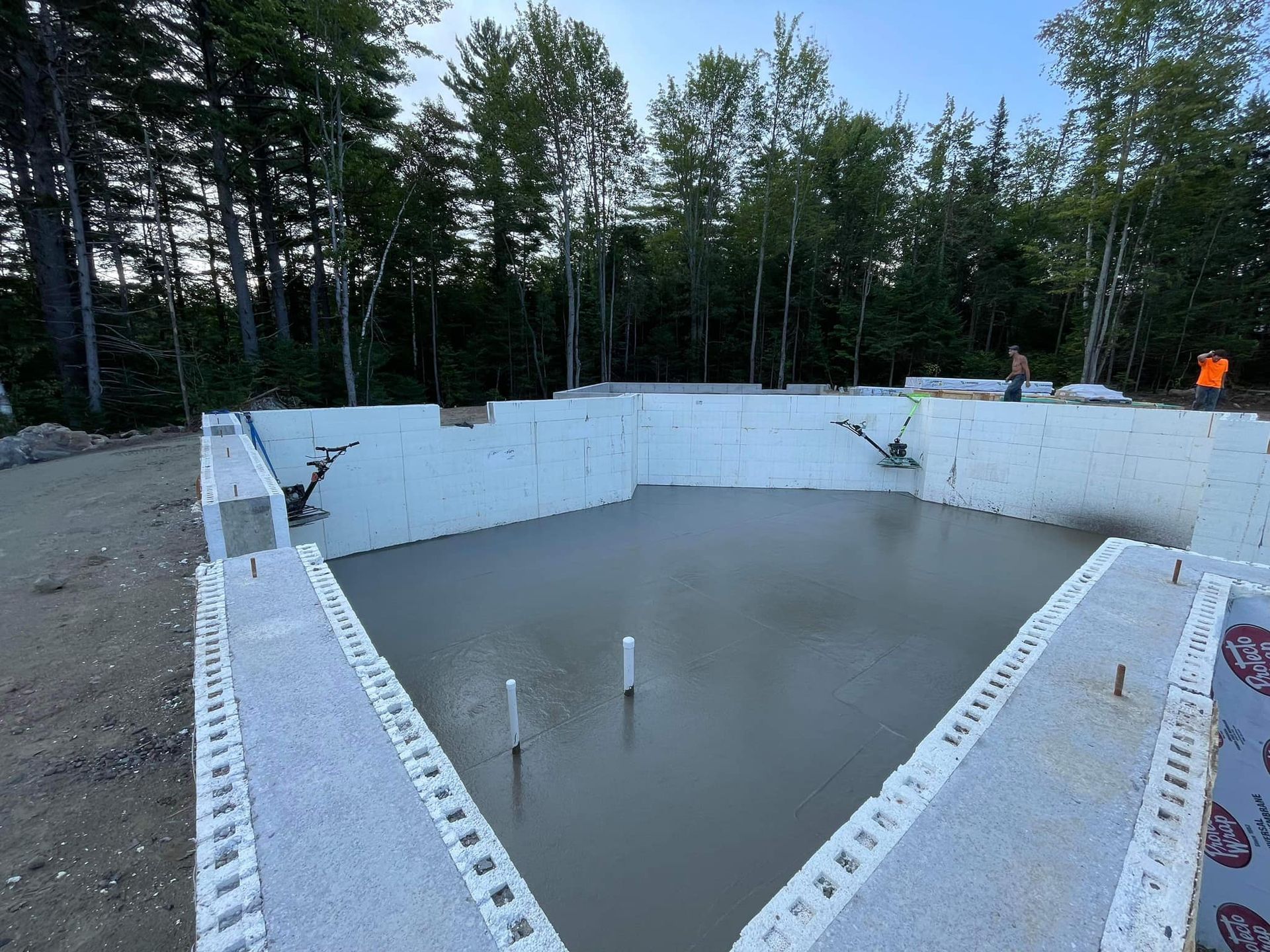 A swimming pool is being built in the middle of a forest.