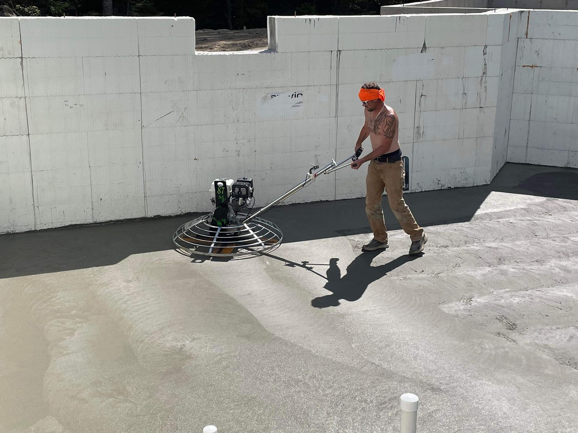 A man is using a machine to finish a concrete floor.
