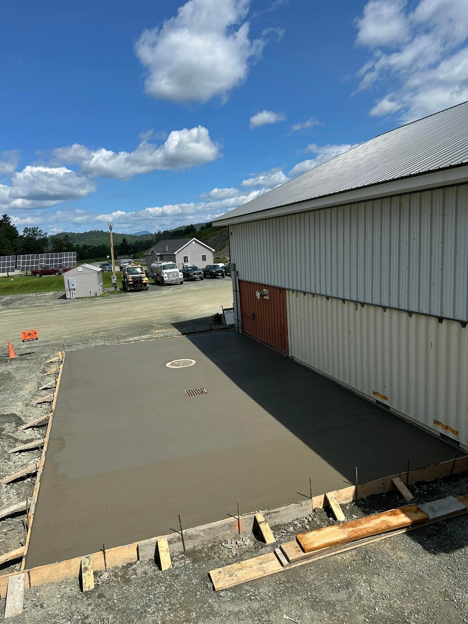 A concrete driveway is being built in front of a building.