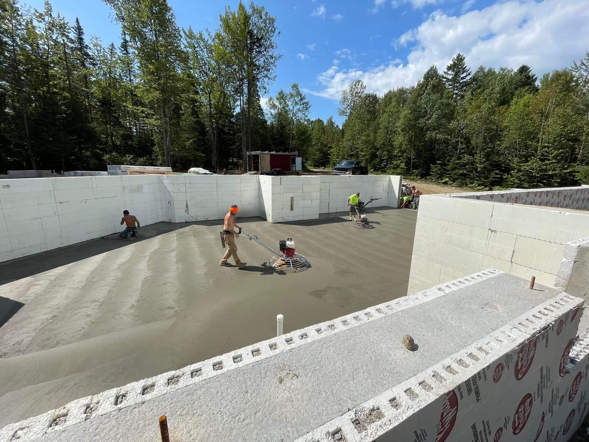 A group of construction workers are working on a concrete floor.
