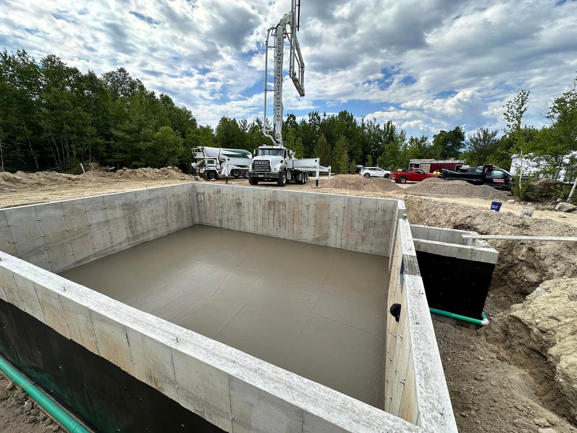 A concrete foundation is being poured in a construction site.