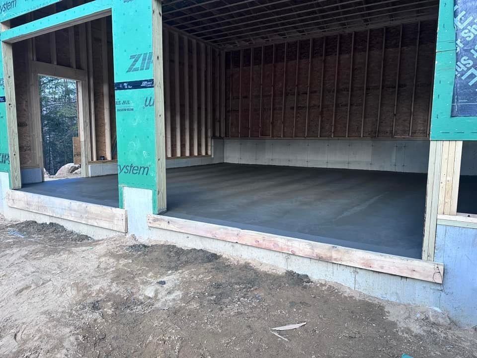 A garage under construction with a concrete floor.
