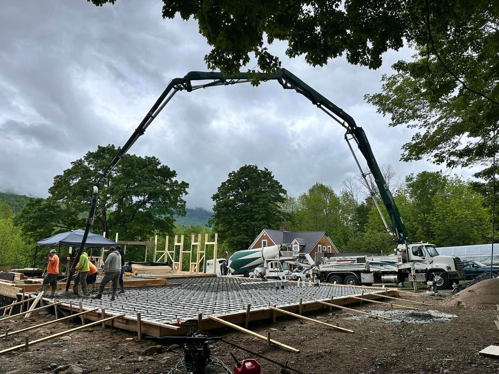 A concrete pump is being used to pour concrete on a construction site.