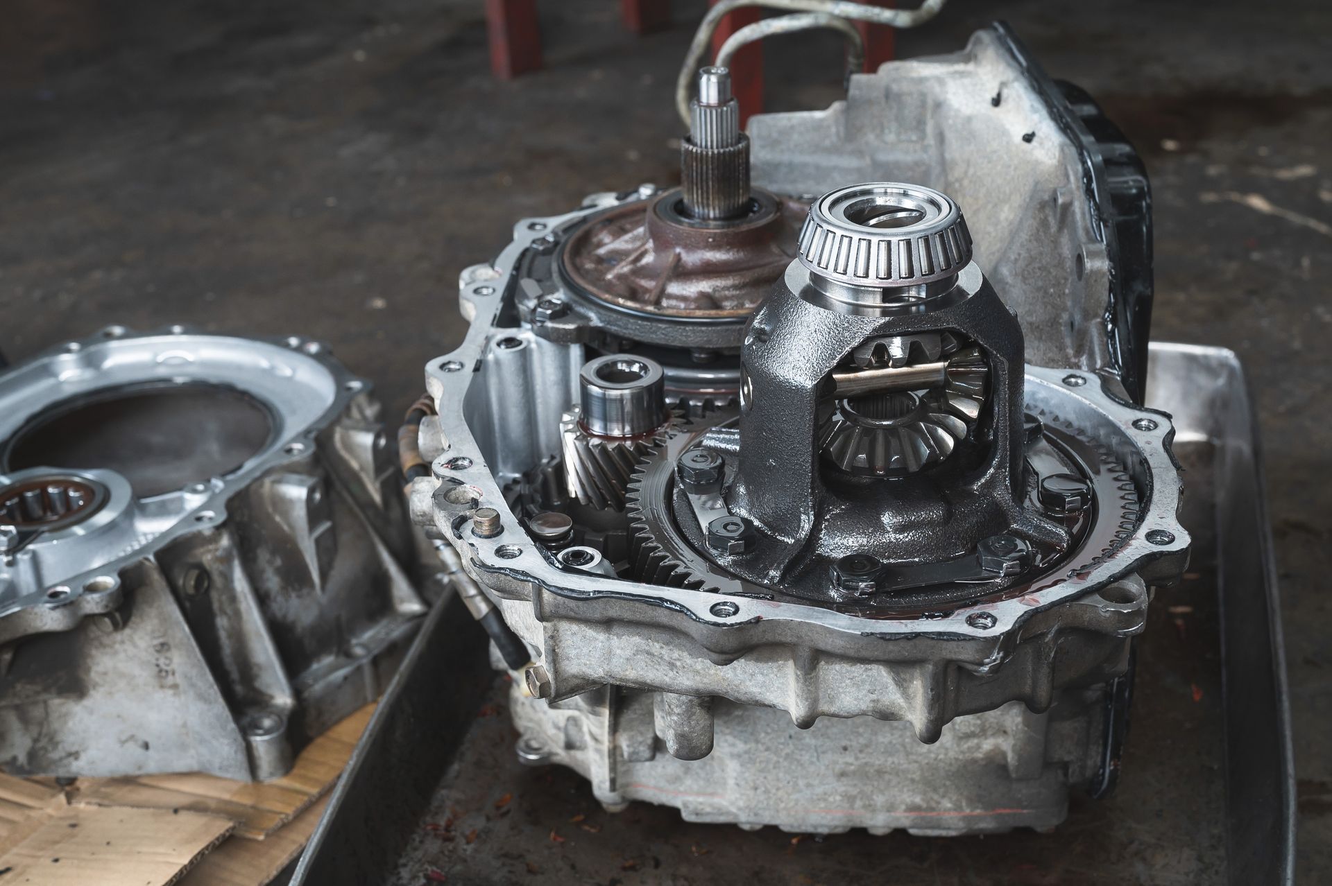 Open car transmission parts on a tray, revealing gears and components, likely during a repair.