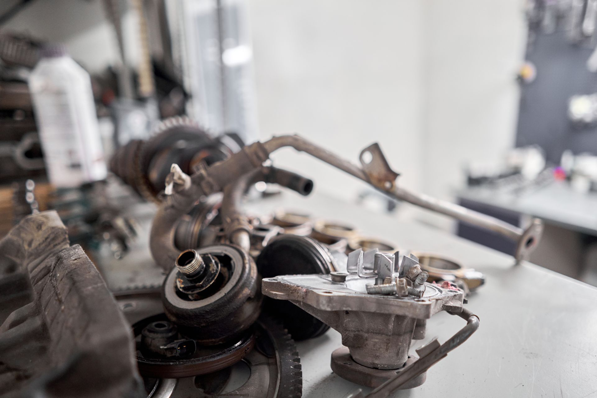 Car parts disassembled on a work surface in a shop.