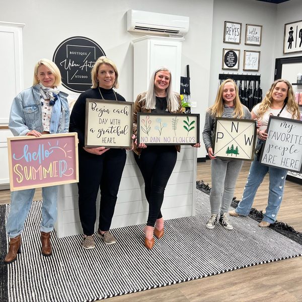 A group of women are standing in a room holding signs.