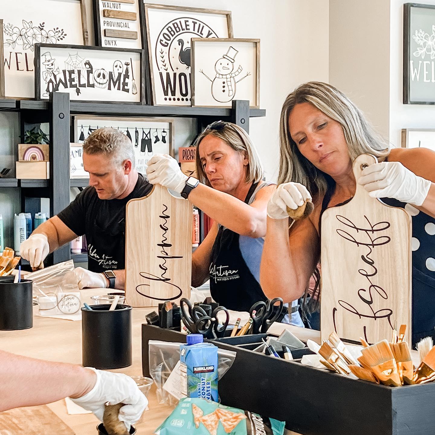 A group of people are sitting at a table holding wooden cutting boards.