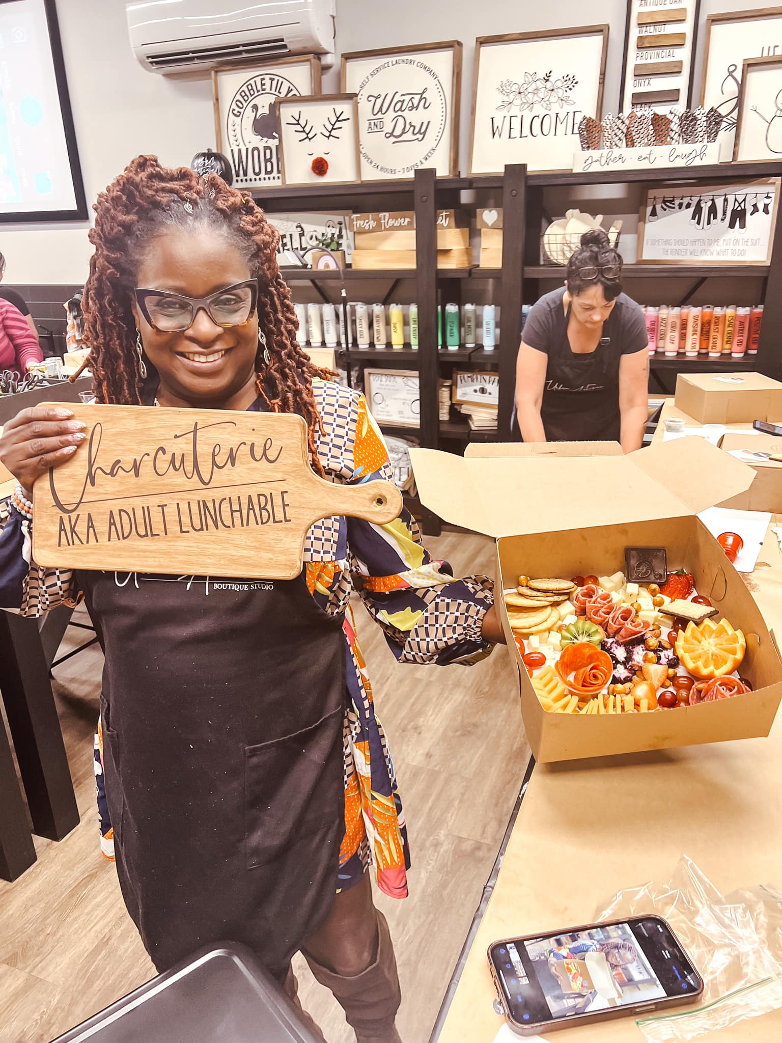 A woman is holding a wooden sign that says furniture design