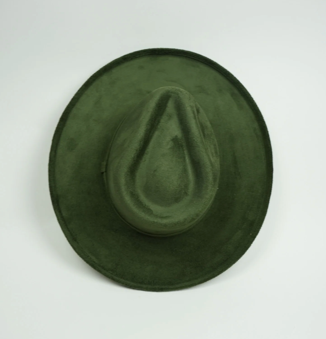 A green hat is sitting on a white surface