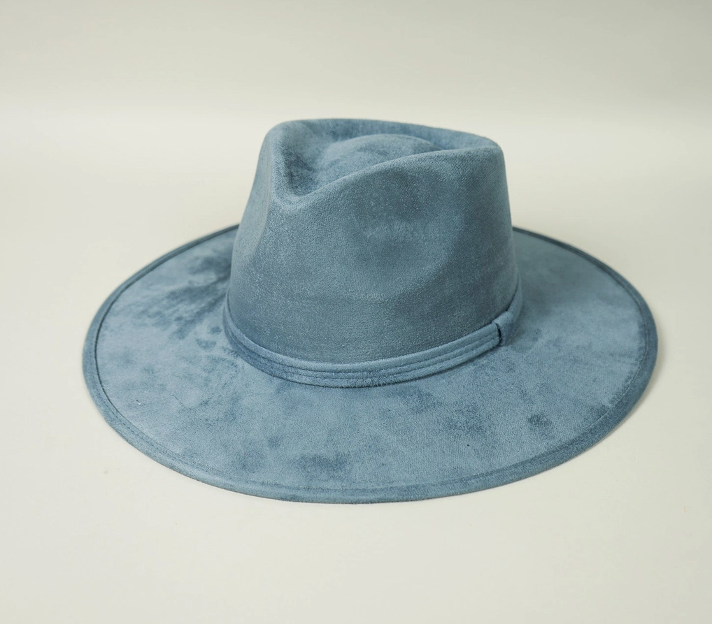 A blue fedora hat is sitting on a white surface