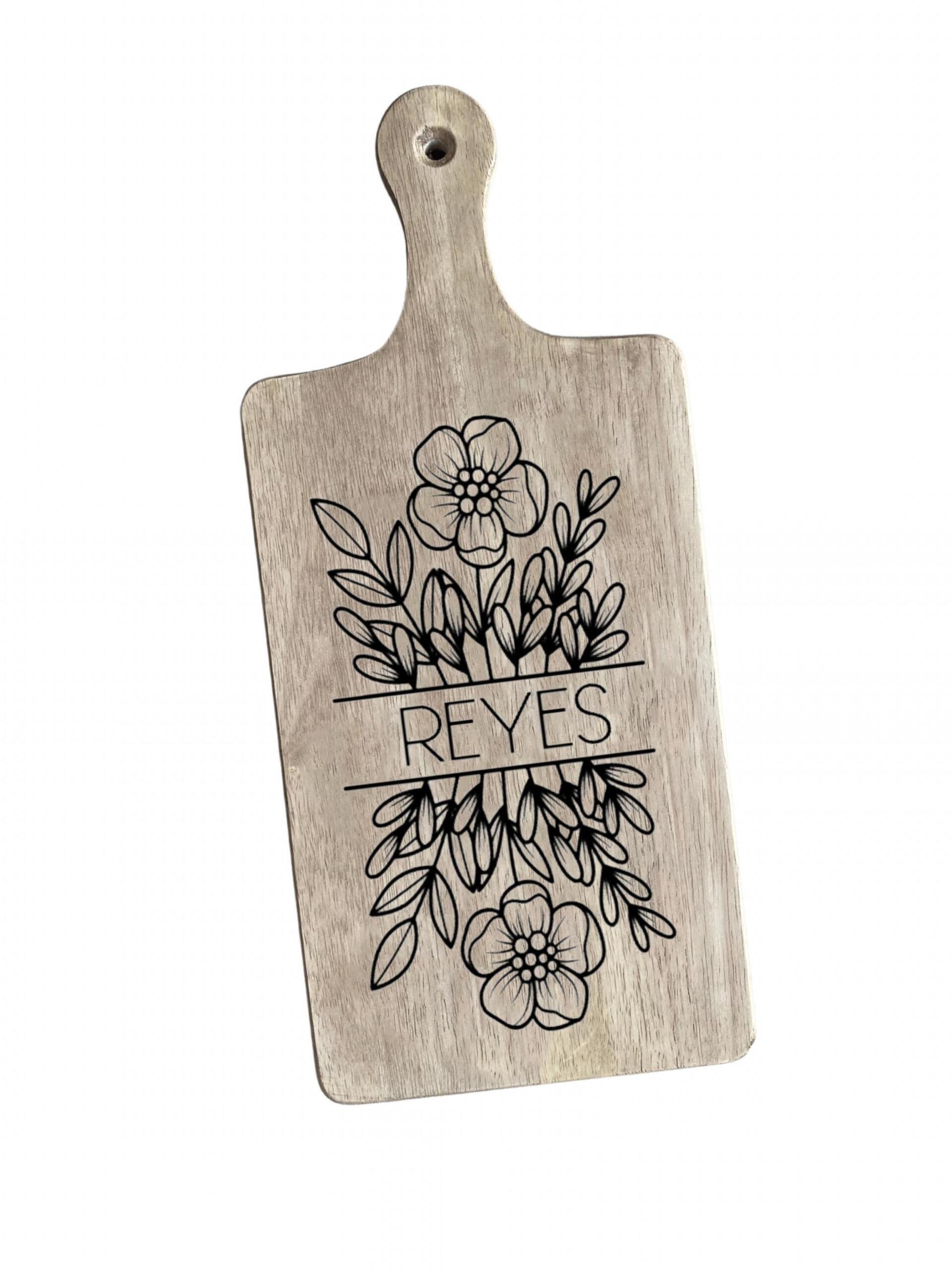 A wooden cutting board with a floral design on it.