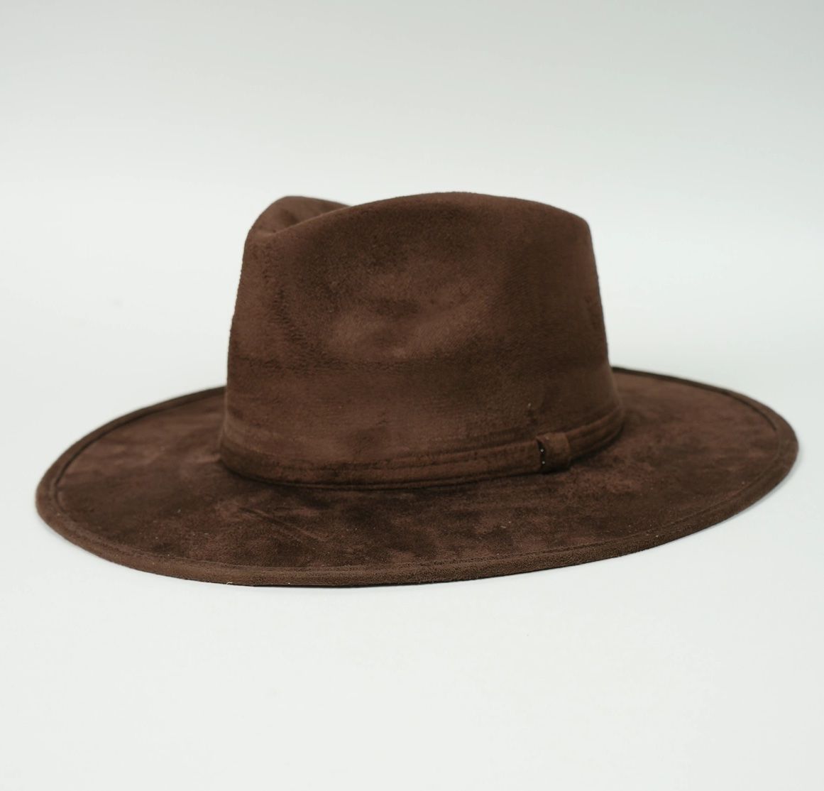 A brown hat is sitting on a white surface