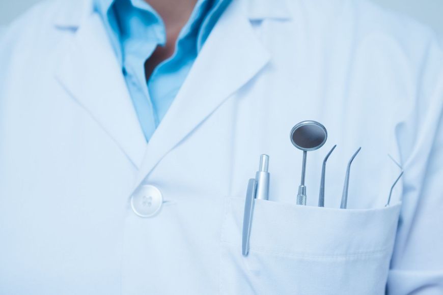 dentista con camice e strumenti diagnostici