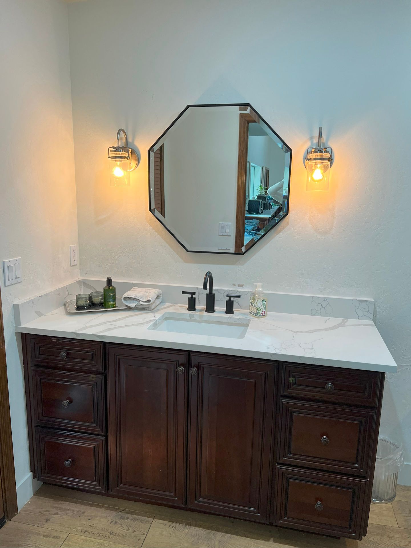 A bathroom with a sink , mirror and cabinets.