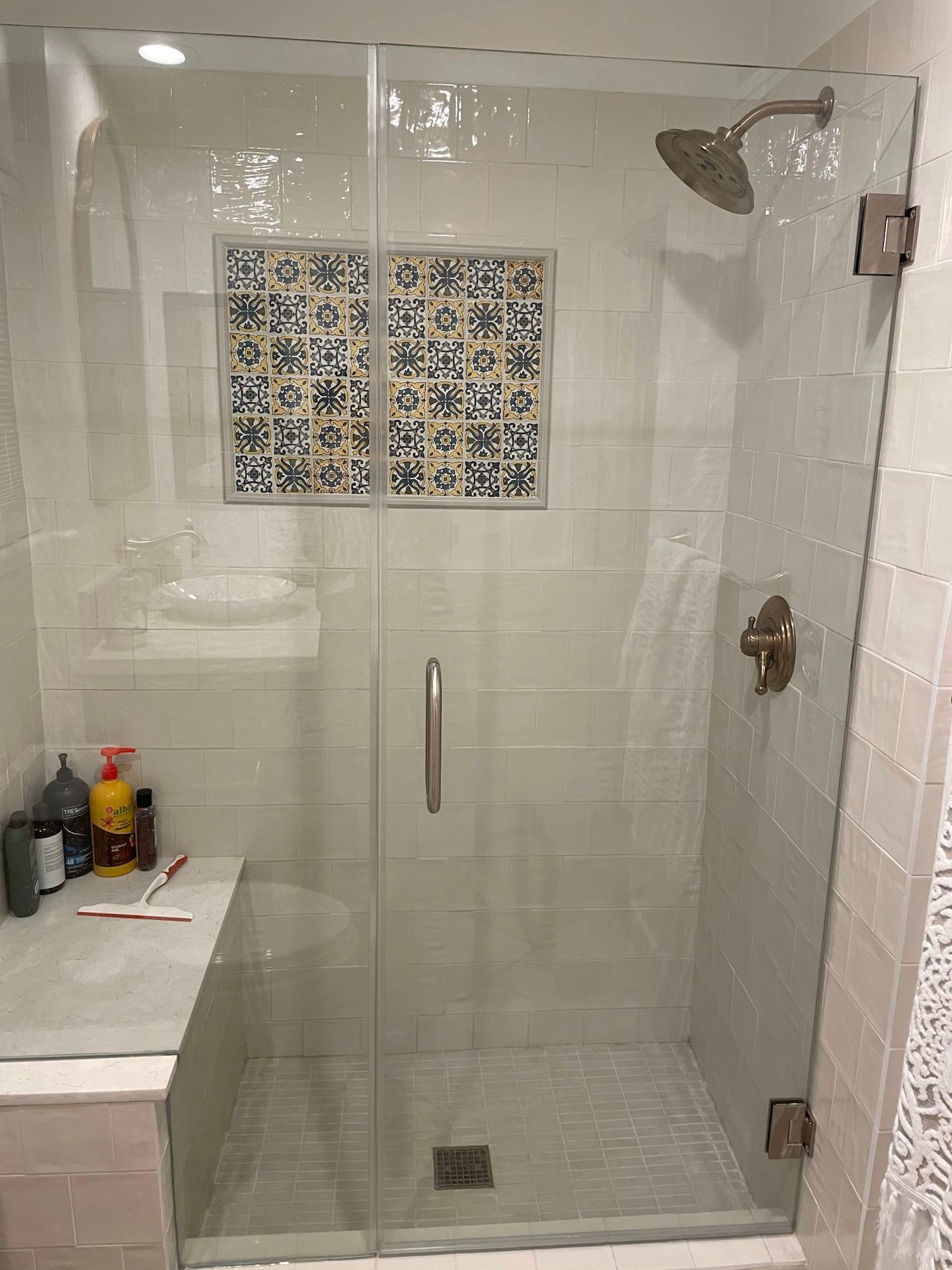 A bathroom with a walk in shower and a sink.