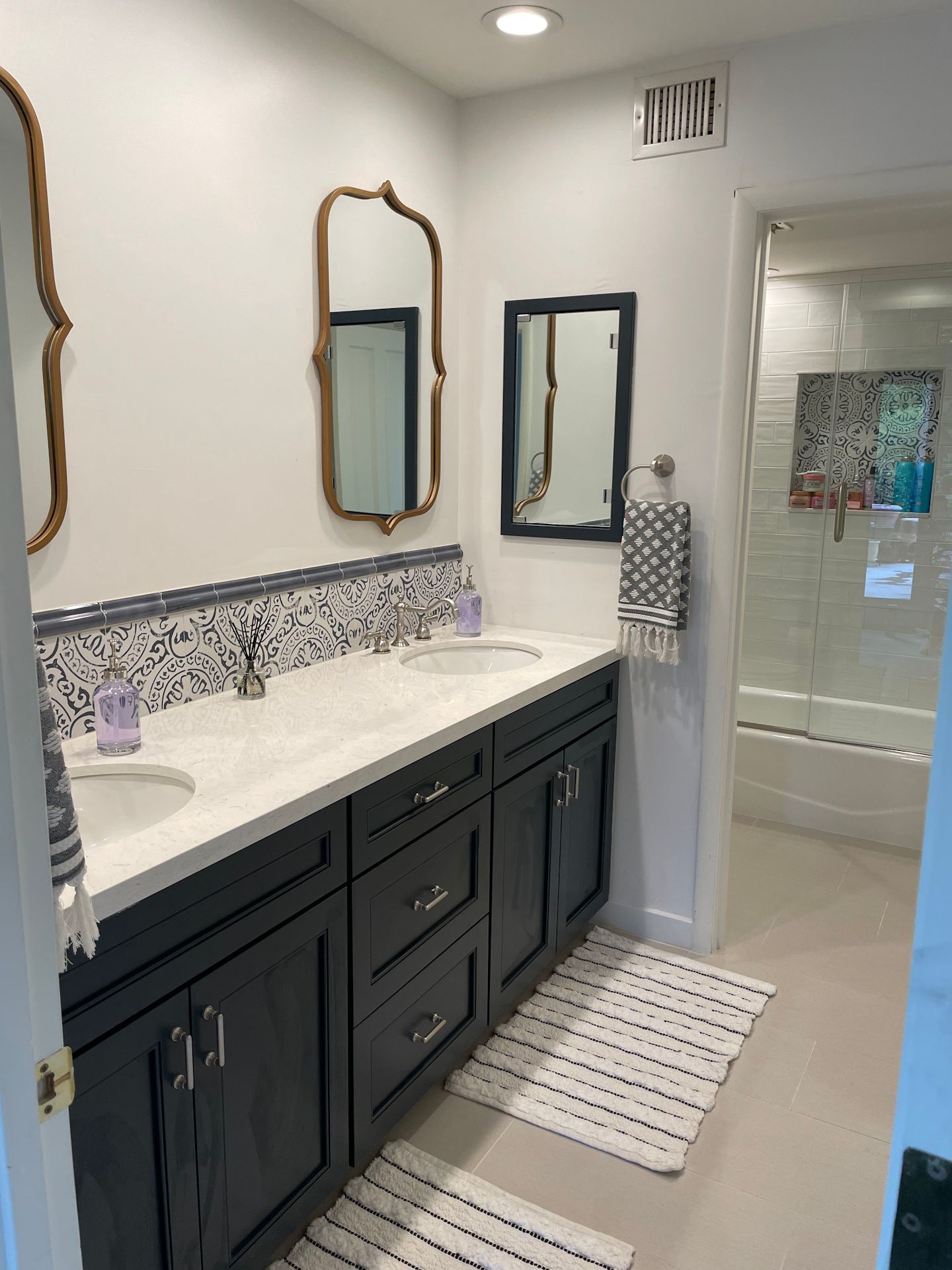 A bathroom with two sinks , a mirror and a rug.