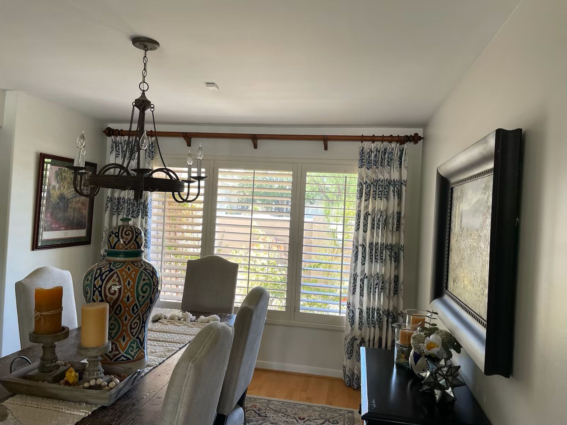 A dining room with a table , chairs , candles and a chandelier.