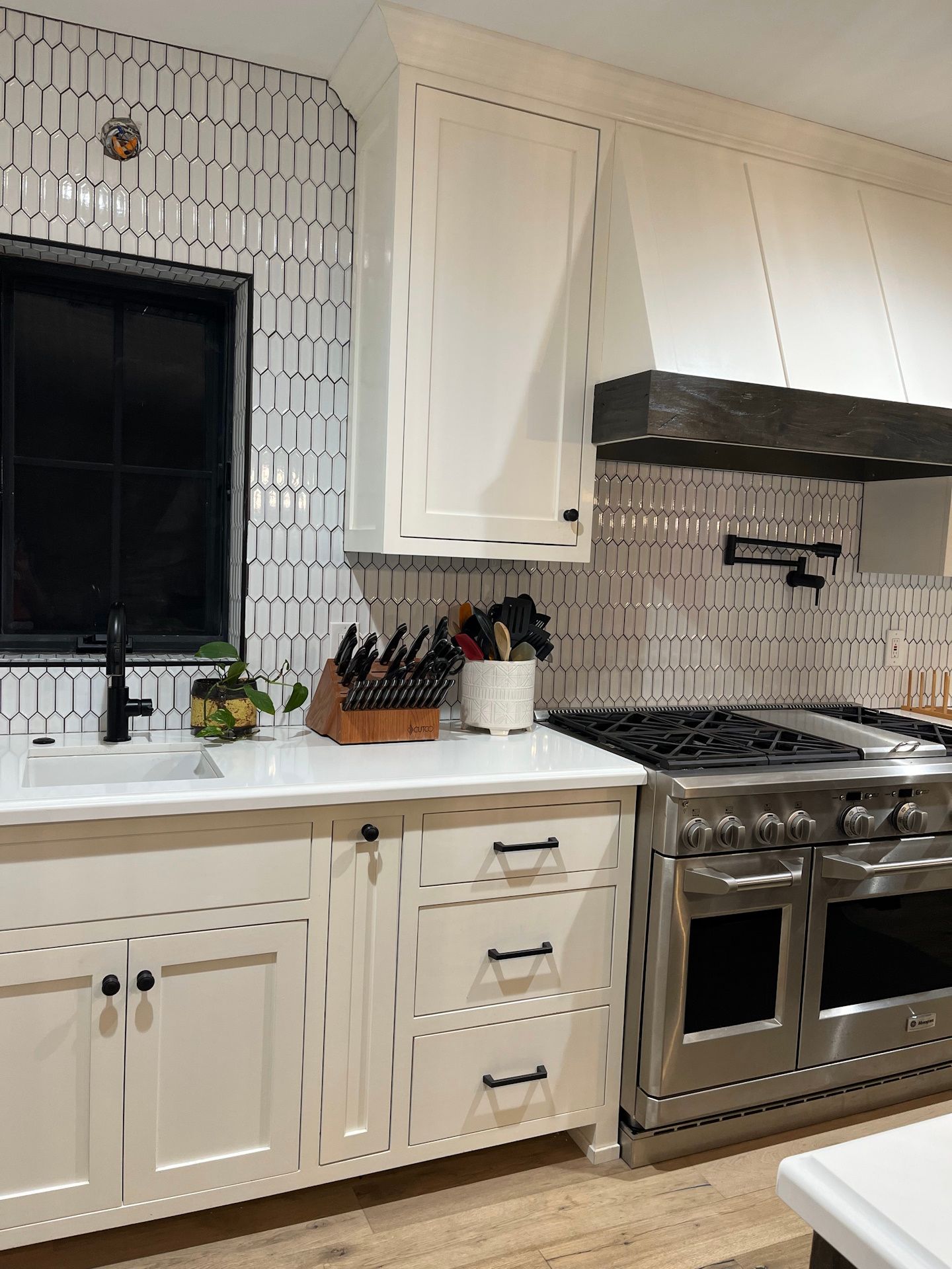 A kitchen with white cabinets and stainless steel appliances