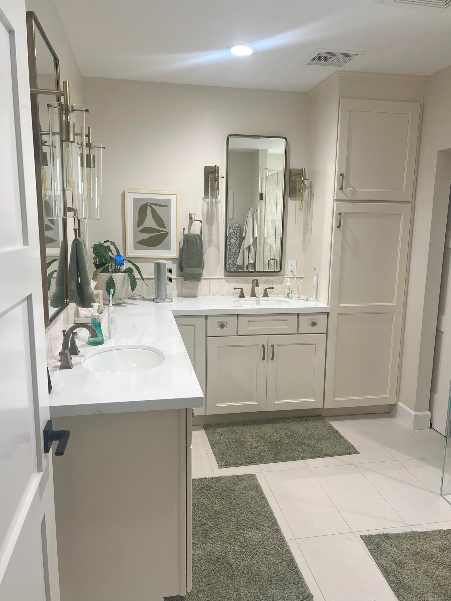 A bathroom with two sinks , a mirror , and a rug.