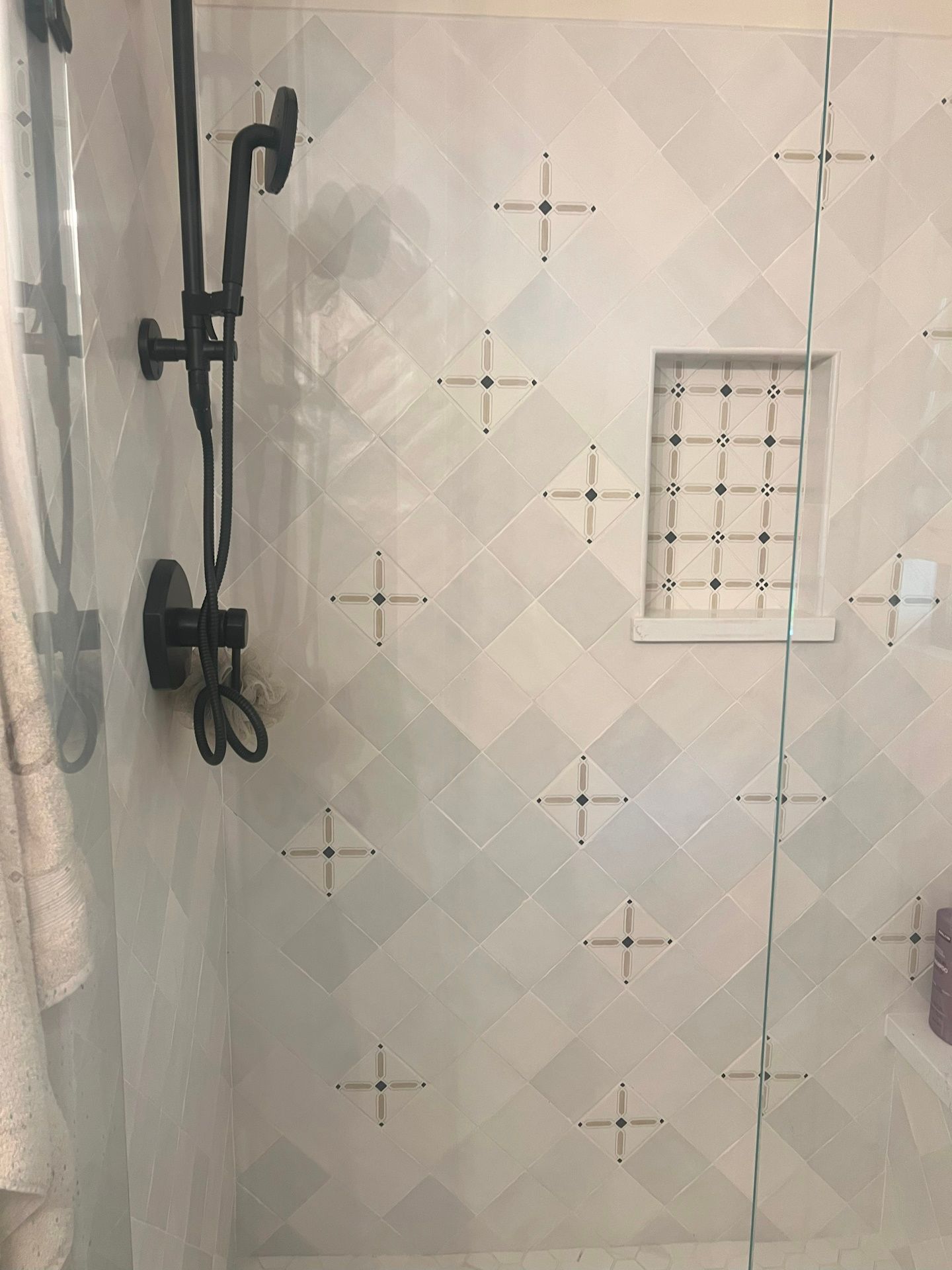 A shower with a sliding glass door and a shower head.