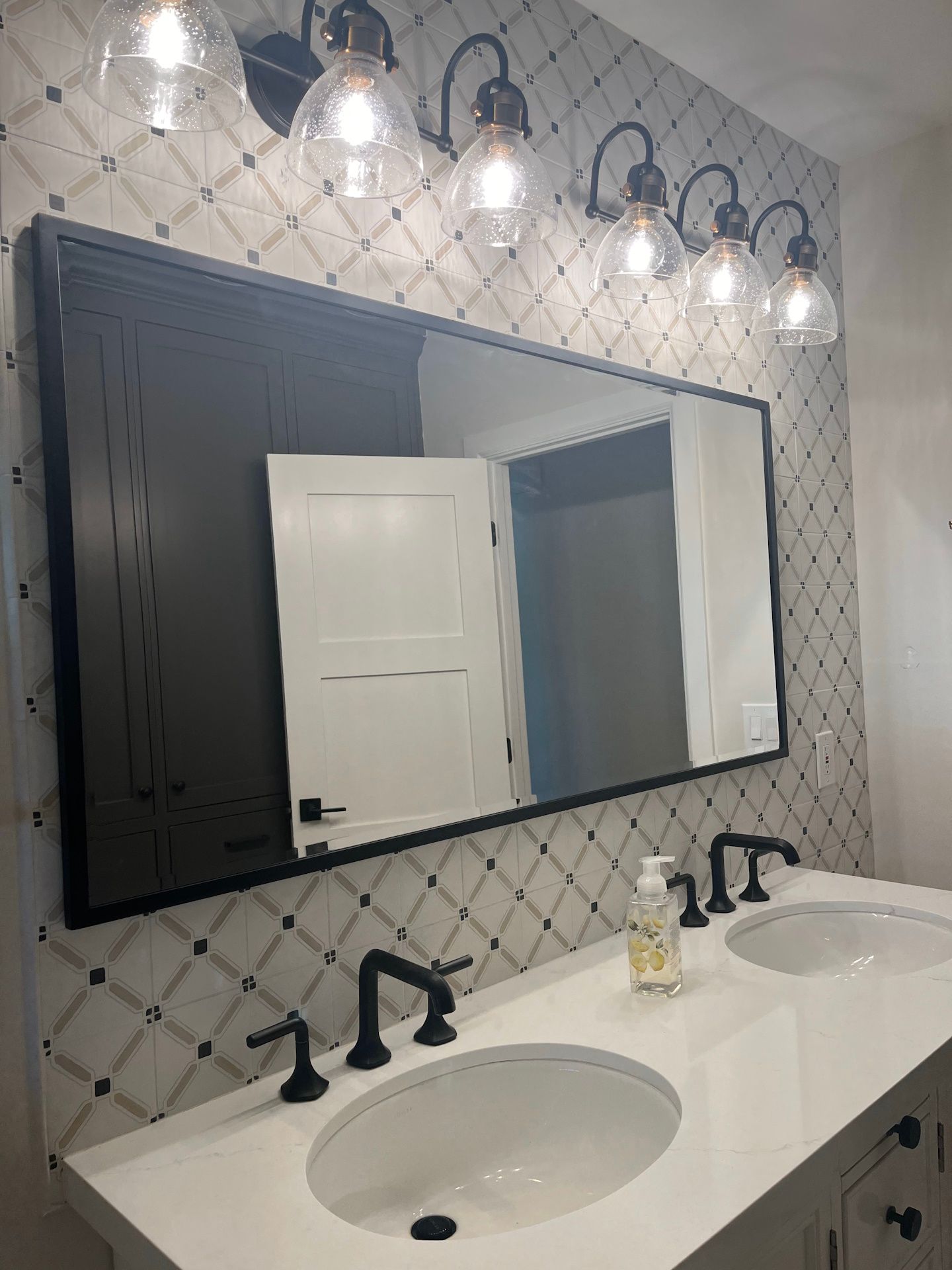 A bathroom with two sinks and a large mirror.