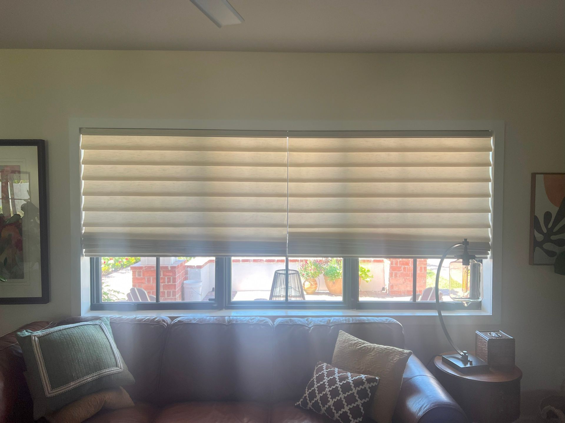 A living room with a couch and a window with blinds on it.