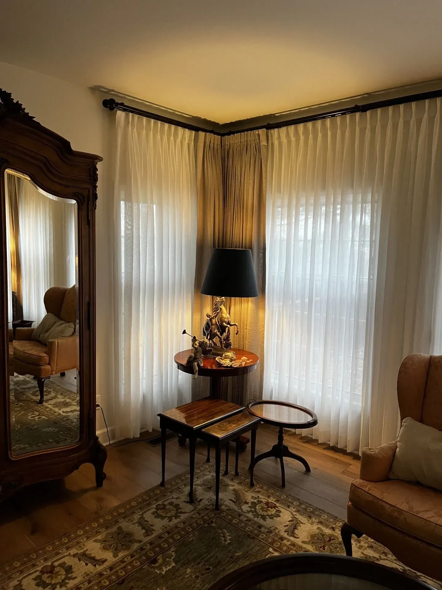 A living room with a couch, chair, table and mirror.