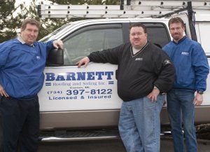 Roofing Specialists — Men Standing Behind Truck in Canton, MI