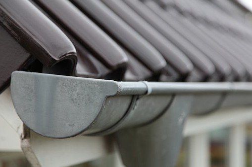 Commercial Gutters — Gutters on Brown Roof in Canton, MI Commercial Gutters — Gutters on Brown Roof in Canton, MI
