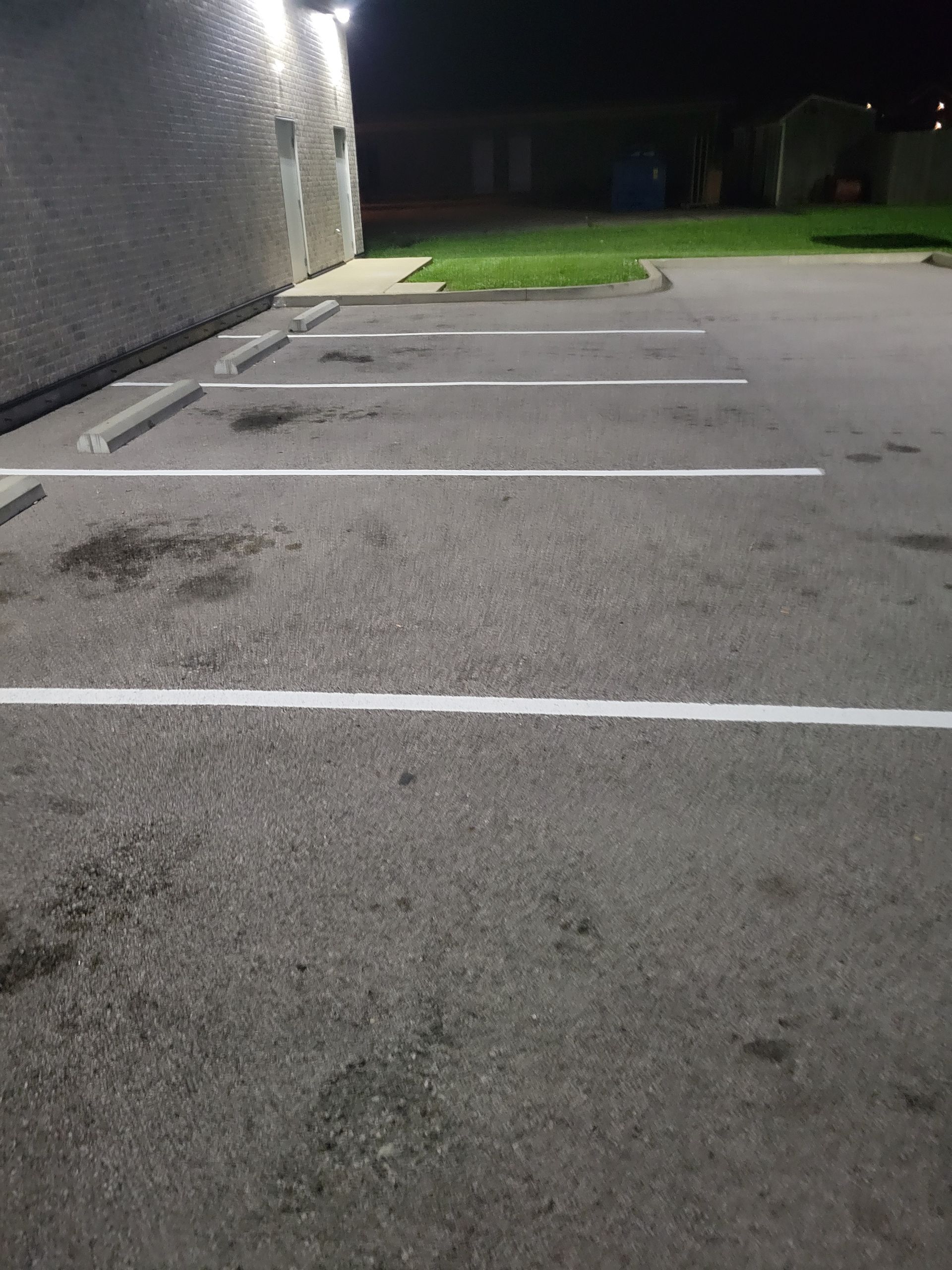 A parking lot with white lines on it at night.